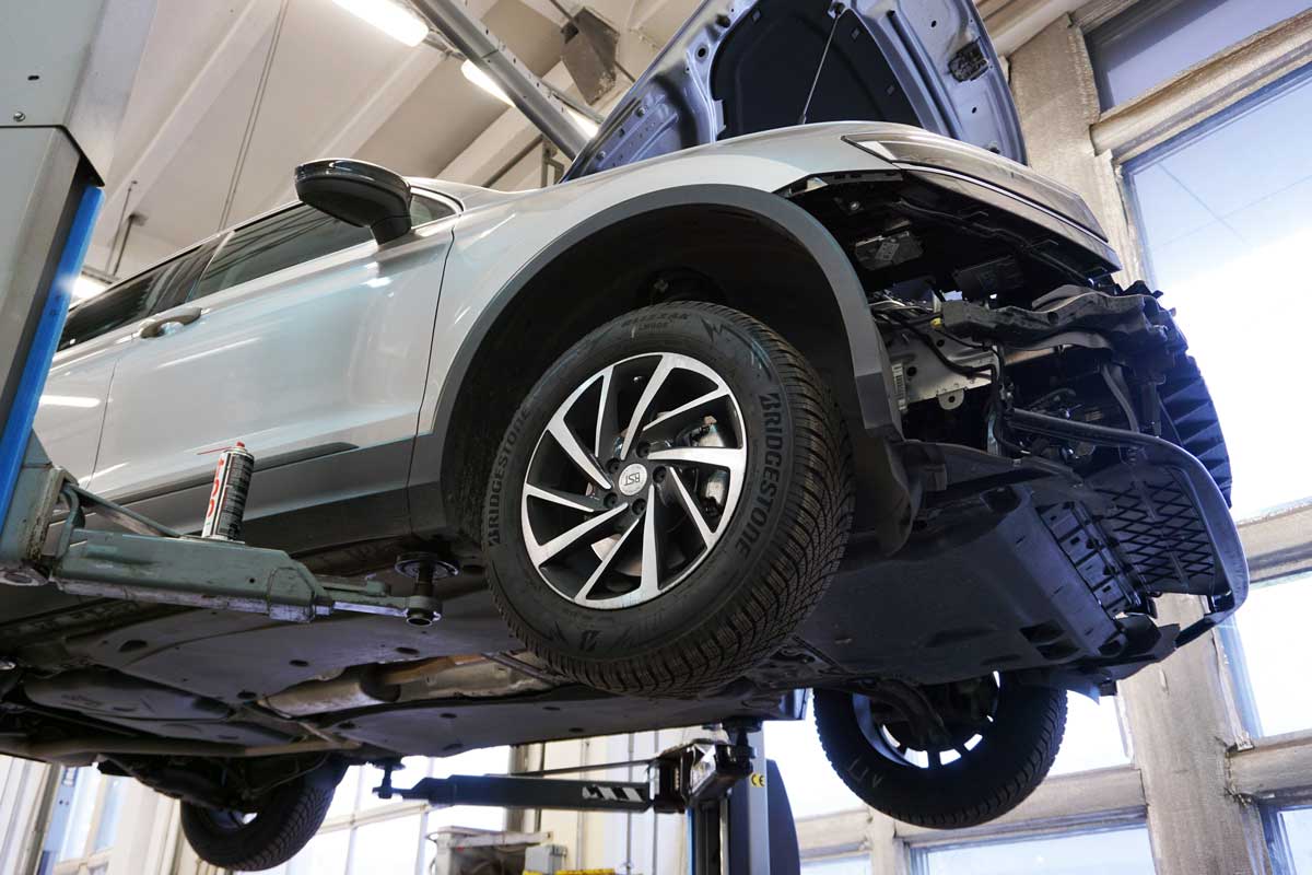 Collision repair technician lifting a vehicle for auto collision repair inspection in Woodbridge, VA